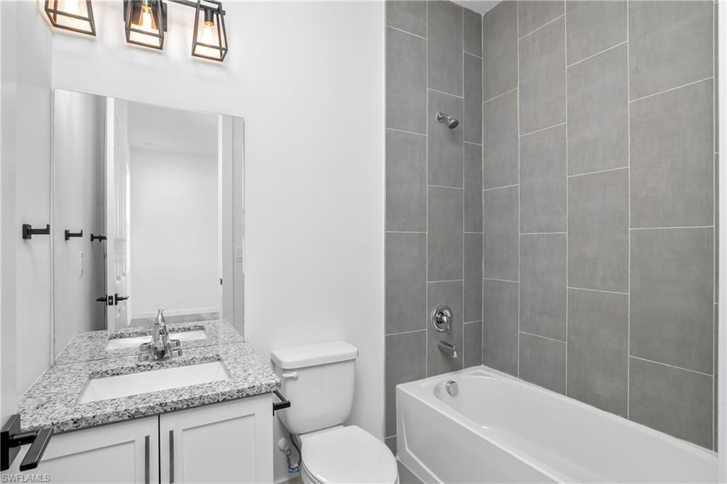 1515 Nelson Road North Cape Coral, FL 33993 - Photo 28 of 38 a bathroom with a granite countertop sink toilet and shower