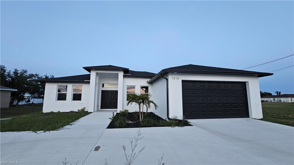 1515 Nelson Road North Cape Coral, FL 33993 - Photo 3 of 38 a front view of a house with a yard and garage