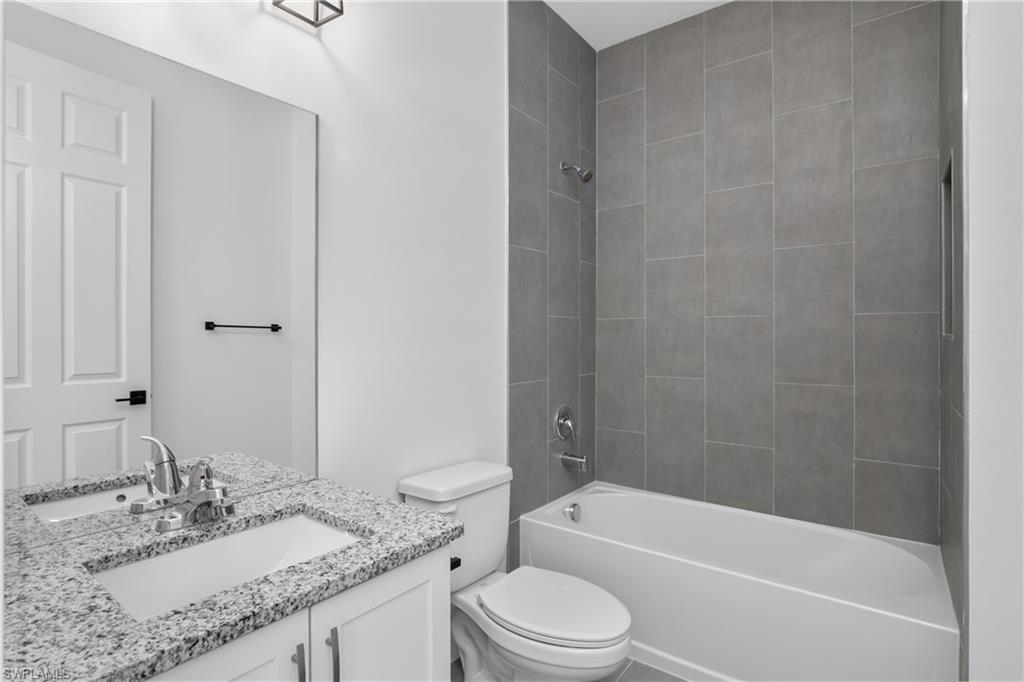 1515 Nelson Road North Cape Coral, FL 33993 - Photo 33 of 38 a bathroom with a granite countertop sink toilet and shower