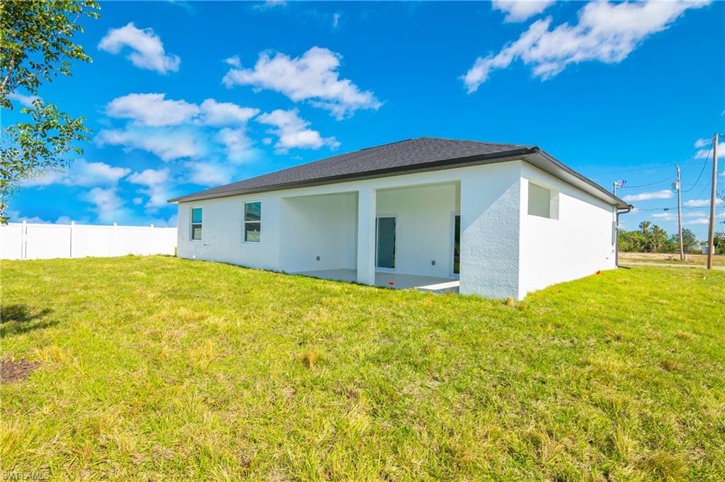 1515 Nelson Road North Cape Coral, FL 33993 - Photo 36 of 38 a view of yellow house with a backyard