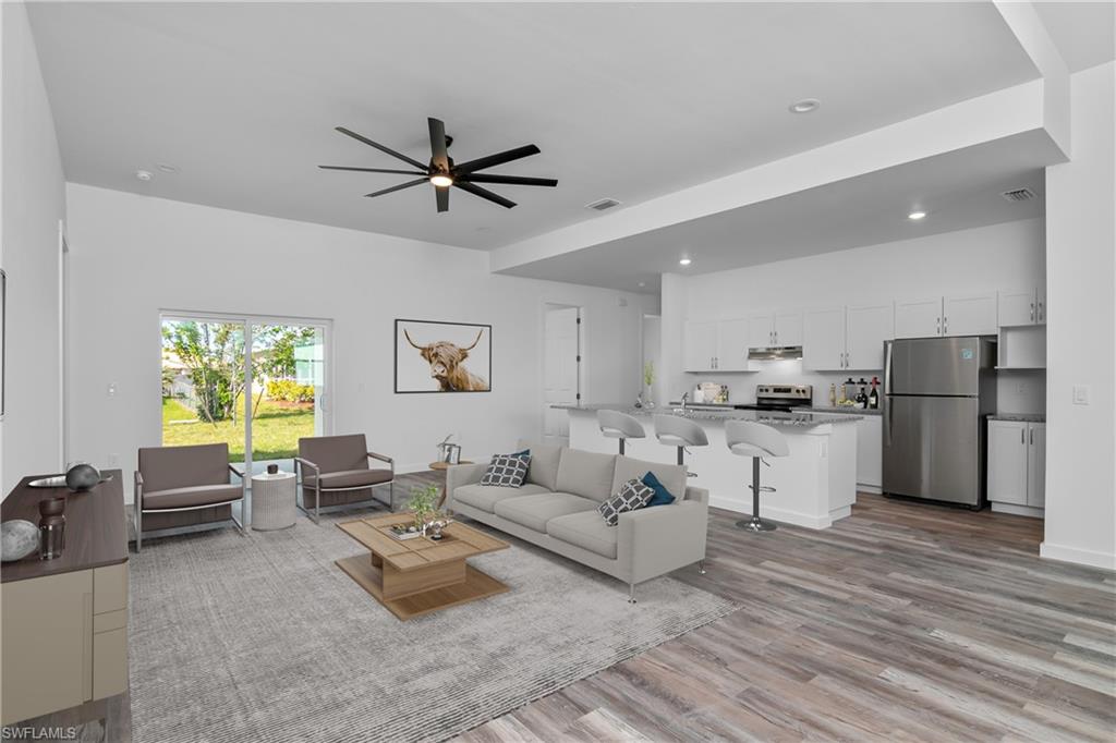 1515 Nelson Road North Cape Coral, FL 33993 - Photo 7 of 38 a living room with furniture white walls and kitchen view