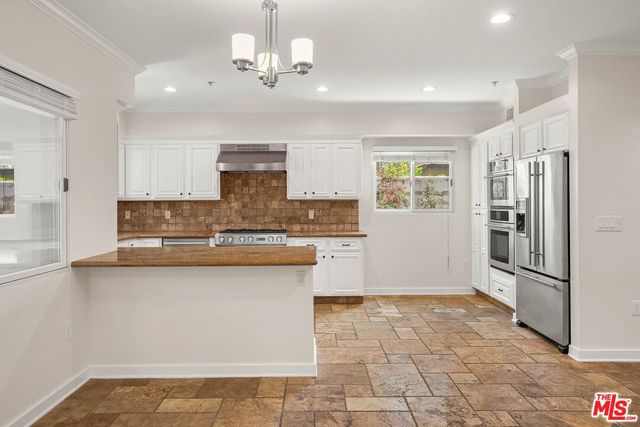 a large kitchen with cabinets and stainless steel appliances