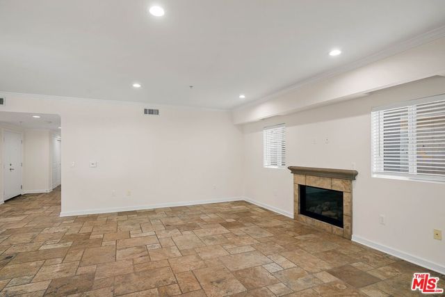 an empty room with a fireplace and window