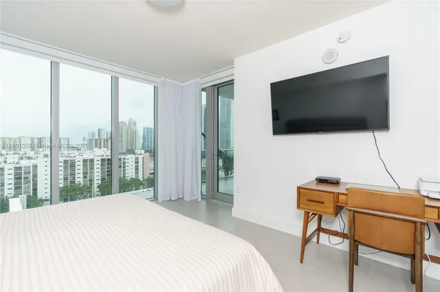 a bedroom with a bed and a flat screen tv