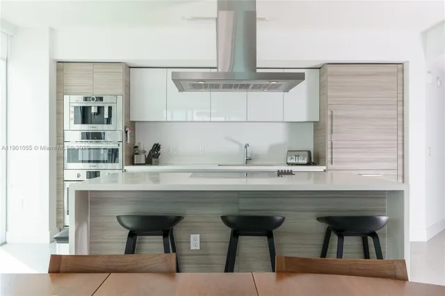 a kitchen with a sink a table and chairs in it