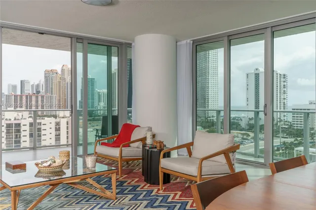 a living room with furniture and floor to ceiling windows