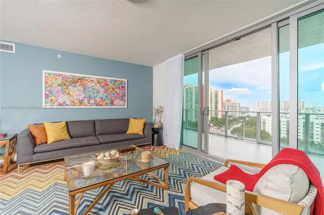 a living room with furniture and a floor to ceiling window
