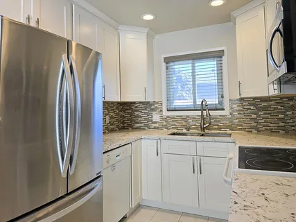 a kitchen with stainless steel appliances a refrigerator sink and cabinets