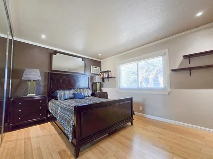 a living room with a bed furniture and next to a window