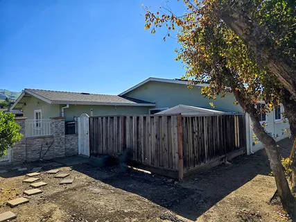 a view of backyard with a small cabin and wooden fence
