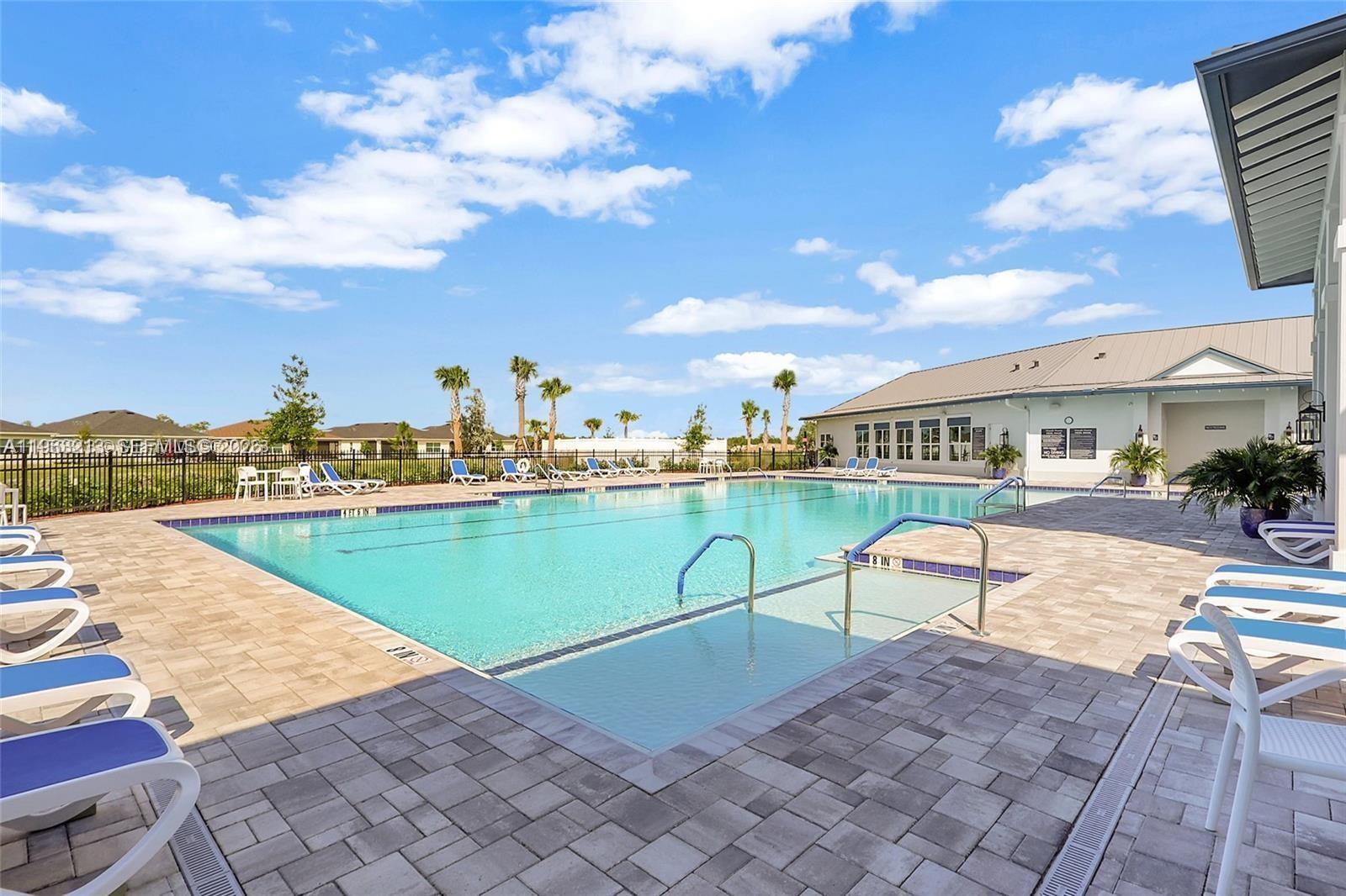 797 Bloomfield Road Port St. Lucie, FL 34984 - Photo 29 of 35 a swimming pool with outdoor seating and city view