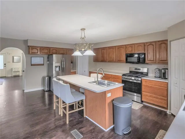 a kitchen with stainless steel appliances a stove a sink and a refrigerator