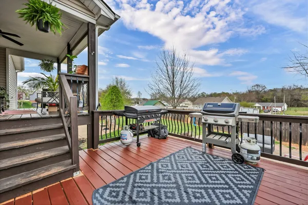 a balcony with wooden floor and outdoor seating