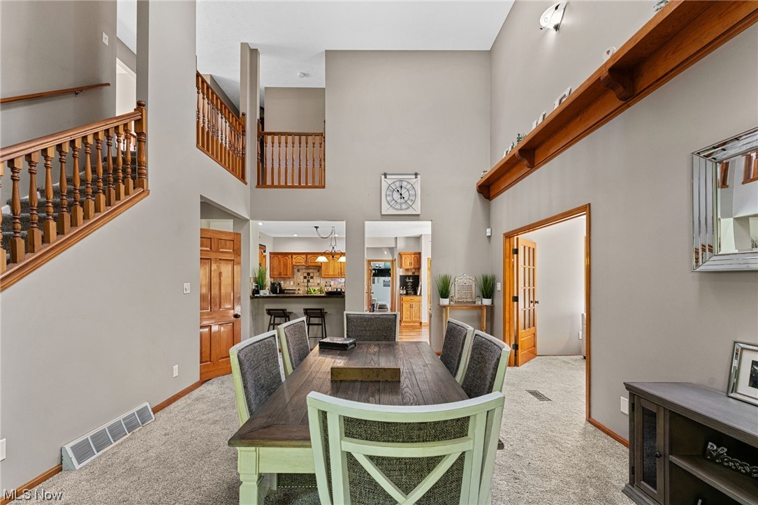7534 Rice Road Amherst, OH 44001 - Photo 20 of 35 Carpeted dining space featuring a chandelier and a high ceiling