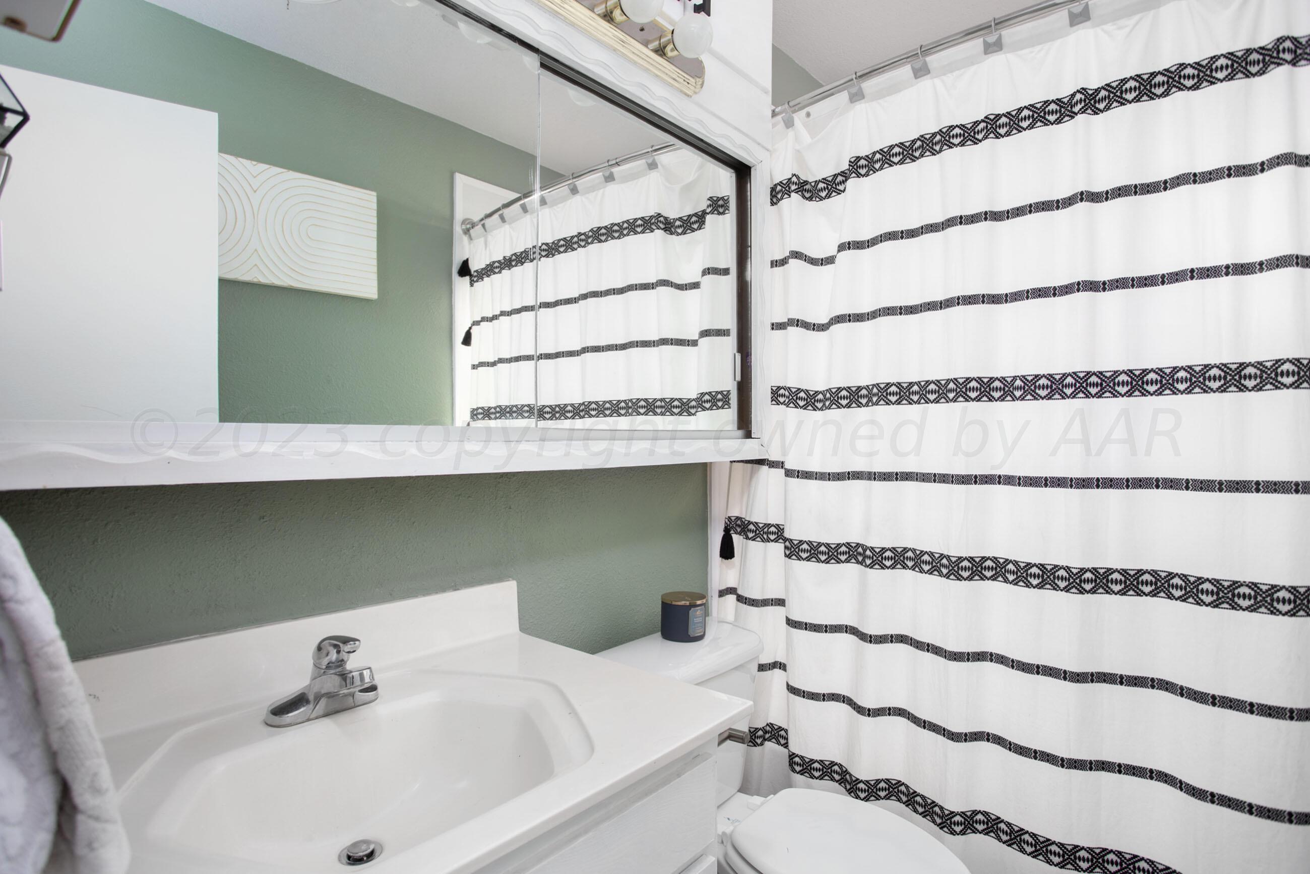 6101 Rutgers Street Amarillo, TX 79109 - Photo 15 of 24 a bathroom with a sink and a mirror