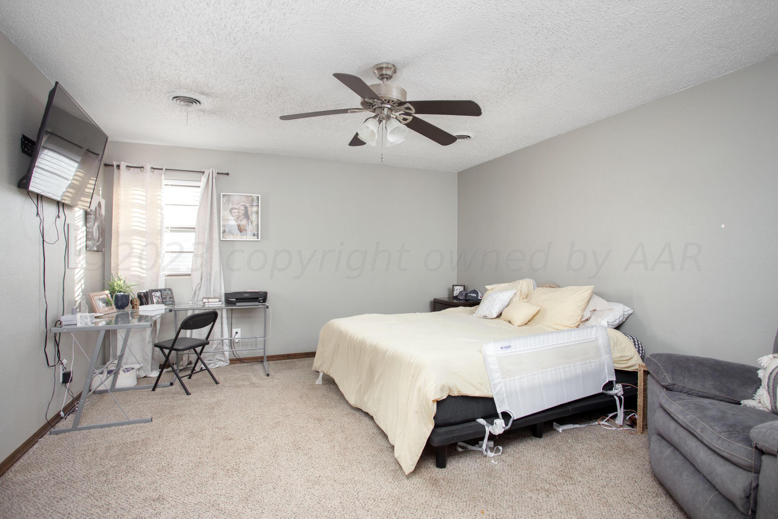 6101 Rutgers Street Amarillo, TX 79109 - Photo 16 of 24 a bedroom with a bed couch and a window