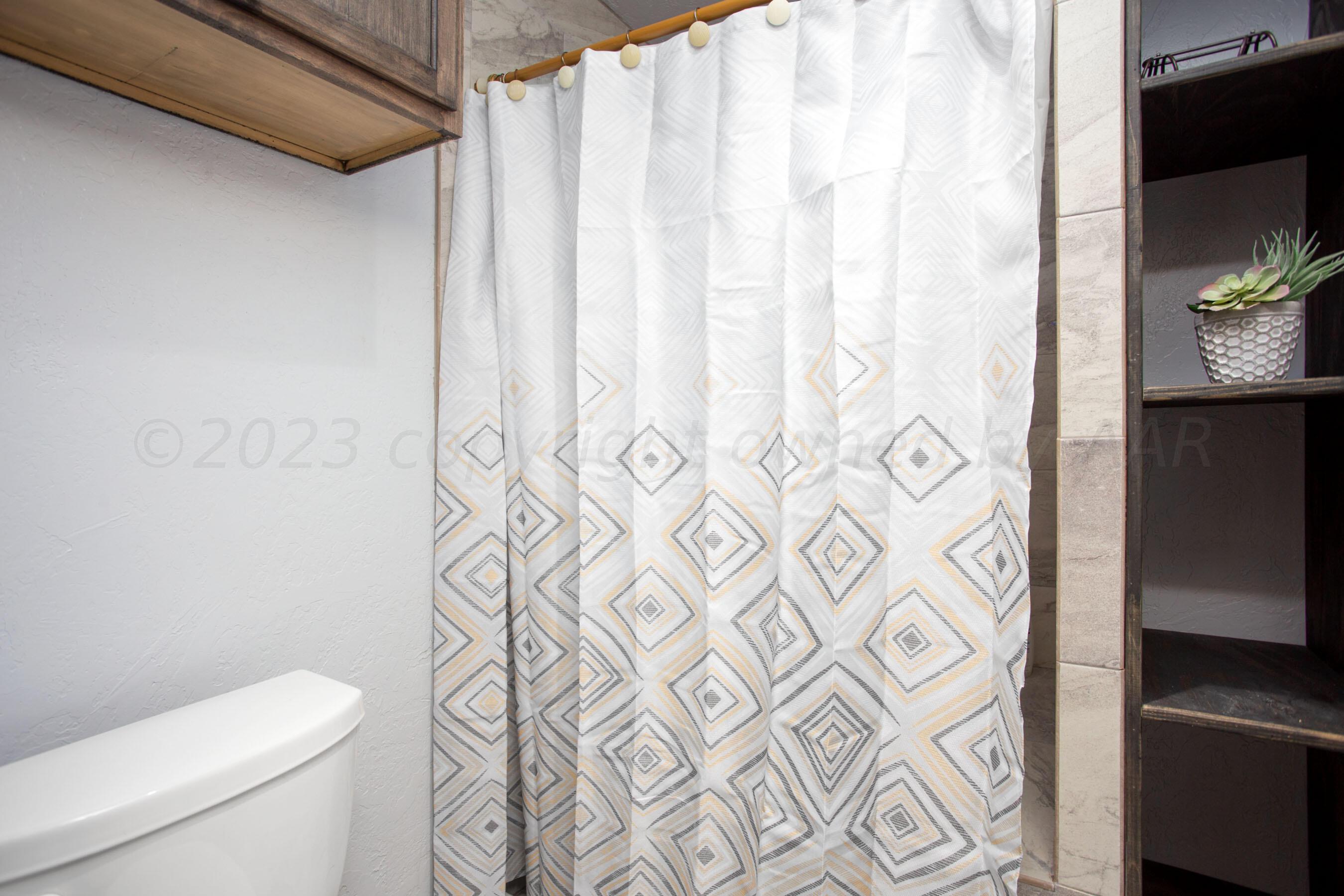 6101 Rutgers Street Amarillo, TX 79109 - Photo 18 of 24 a white toilet sitting next to a shower curtain
