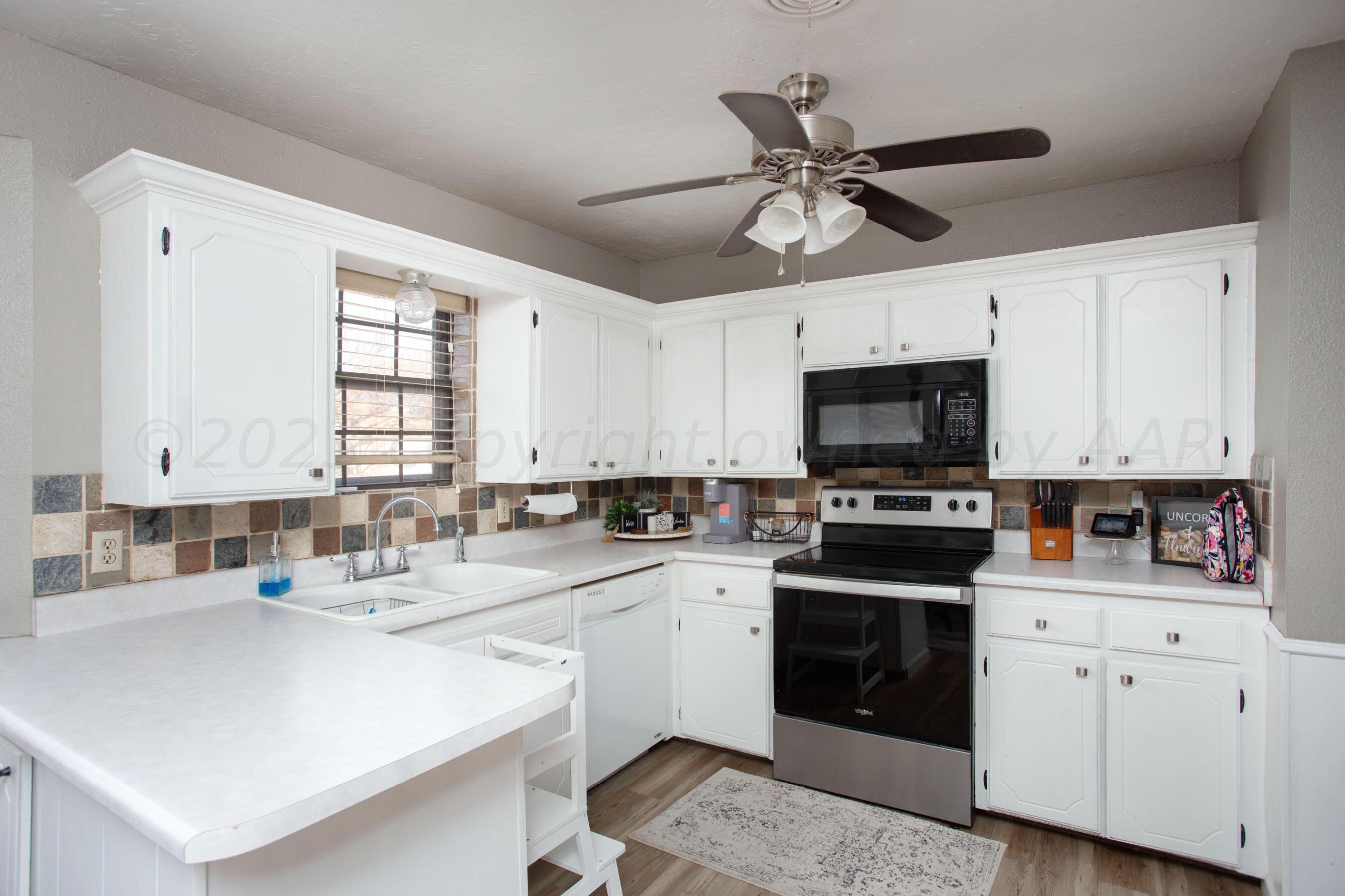 6101 Rutgers Street Amarillo, TX 79109 - Photo 9 of 24 a kitchen with a sink a stove and cabinets