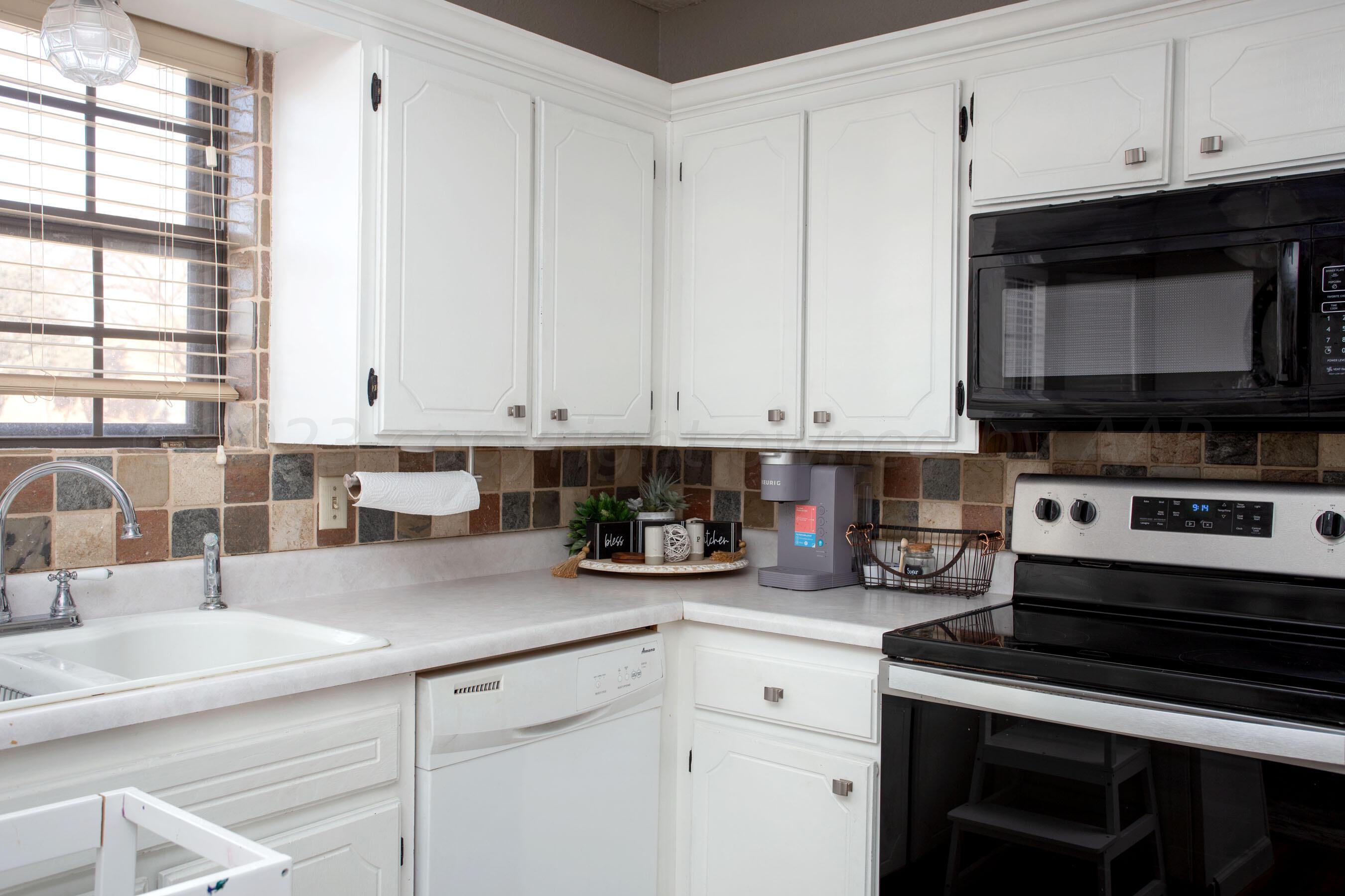 6101 Rutgers Street Amarillo, TX 79109 - Photo 10 of 24 a kitchen with stainless steel appliances white cabinets and a sink