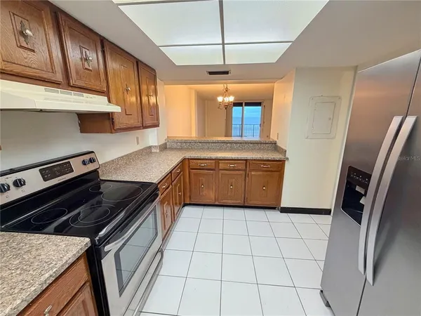 a kitchen with stainless steel appliances granite countertop a stove a refrigerator and a sink