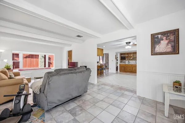 a living room with furniture a flat screen tv and kitchen view