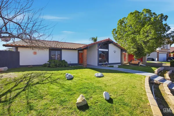 a front view of house with yard and trees