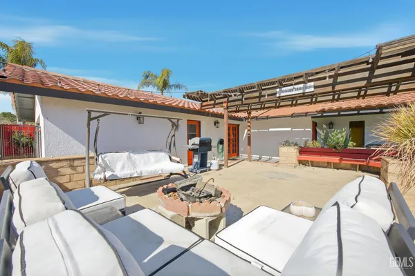 a roof deck with couch and chairs