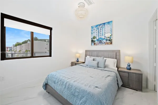 a bedroom with a bed and a lamp on dresser