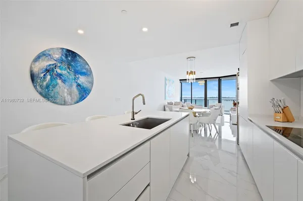 a kitchen with a dining table chairs and white cabinets