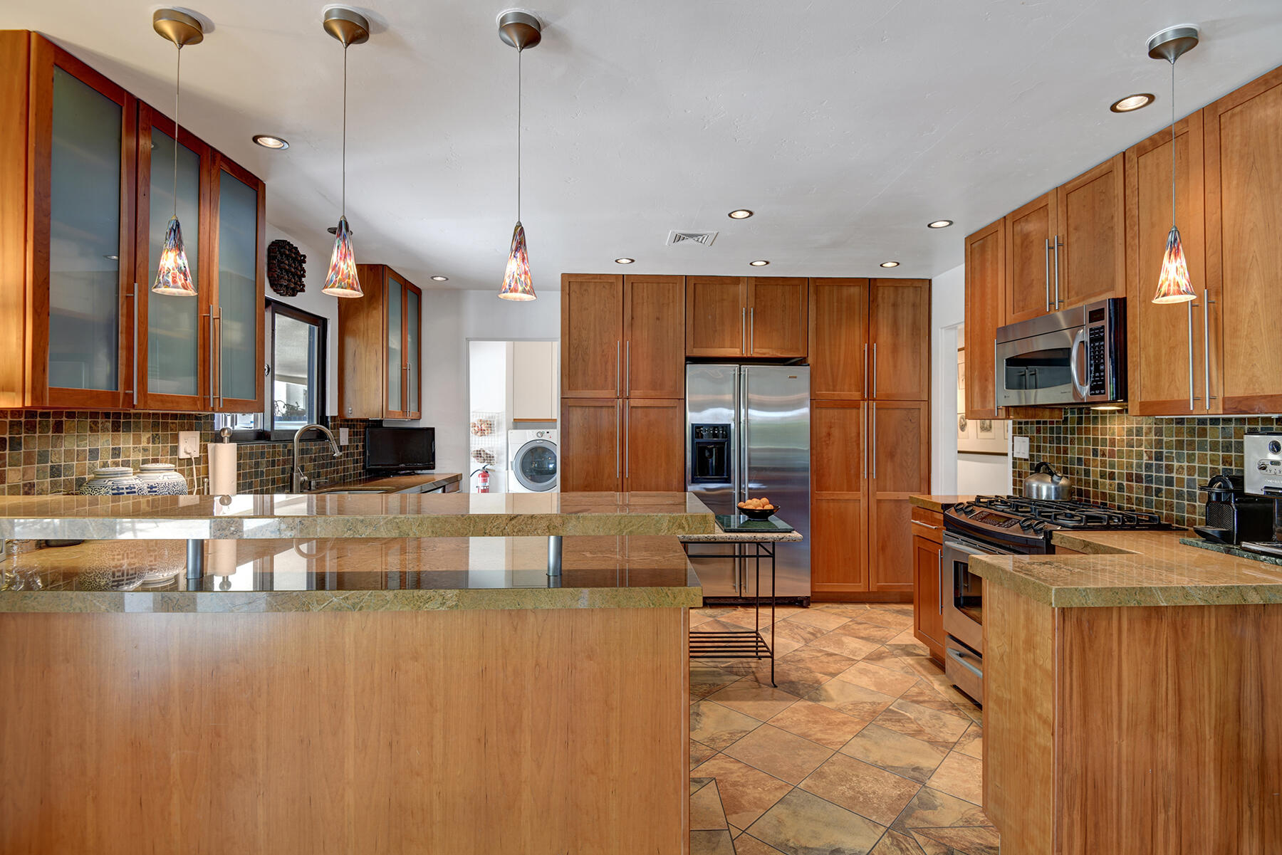 2915 Guadalupe Road Palm Springs, CA 92264 - Photo 20 of 52 a kitchen with kitchen island granite countertop a stove a sink a refrigerator white cabinets and wooden floor