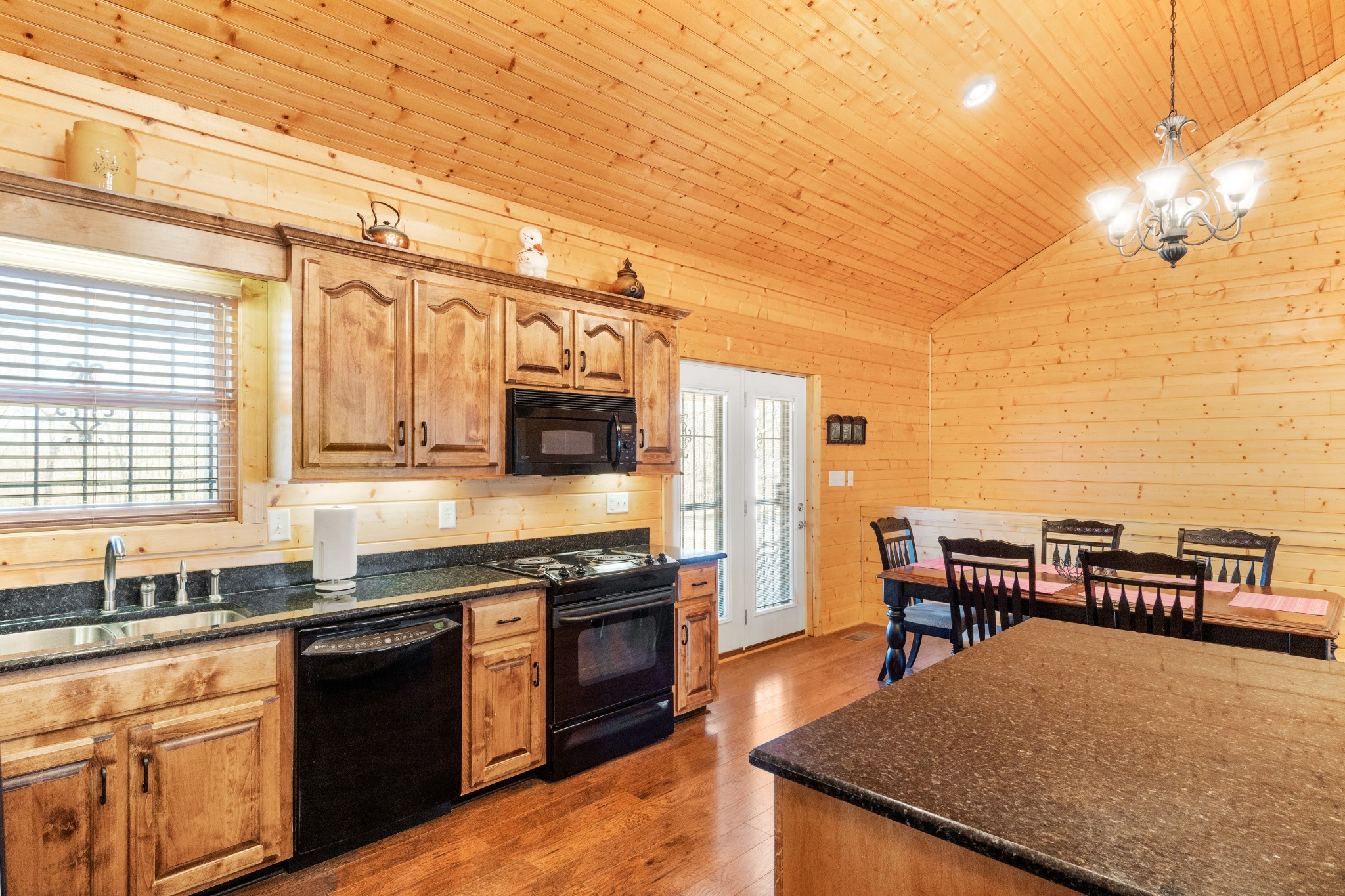 1760 Point Pleasant Road Buchanan, TN 38222 - Photo 26 of 50 a kitchen with stainless steel appliances granite countertop a stove a sink dishwasher a dining table and chairs with wooden floor