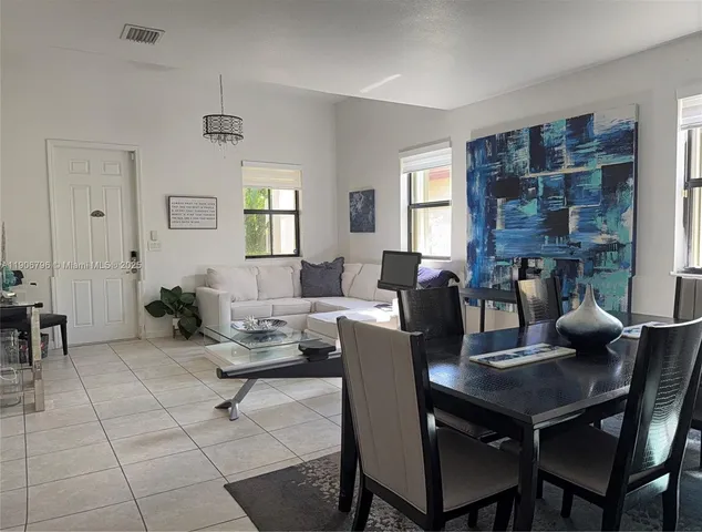 a living room with furniture a chandelier and a dining table