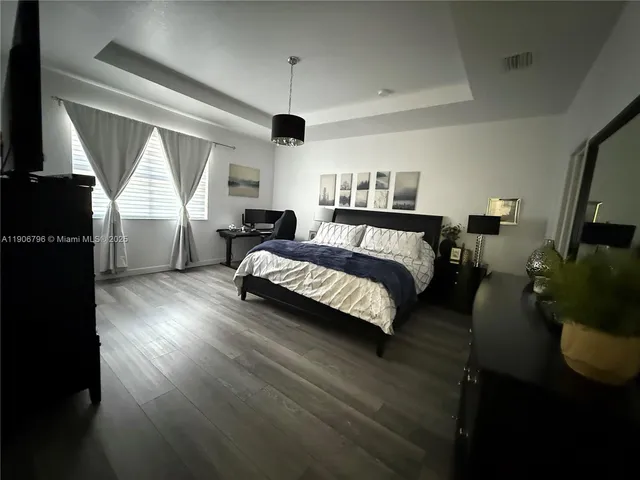 a bedroom with furniture and a large window