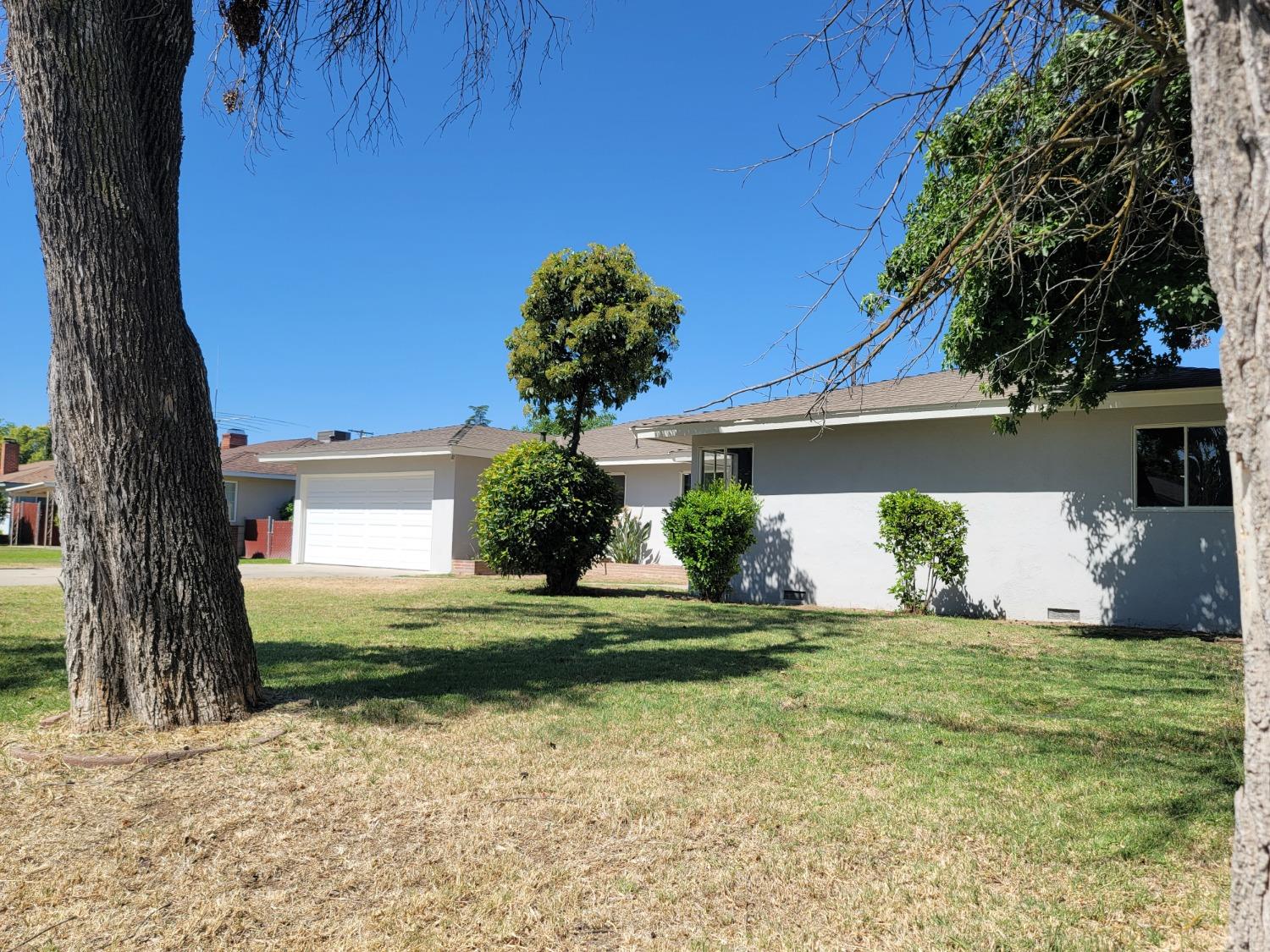 522 Willis Avenue Madera, CA 93637 - Photo 3 of 40 a front view of a house with a yard garage and tree