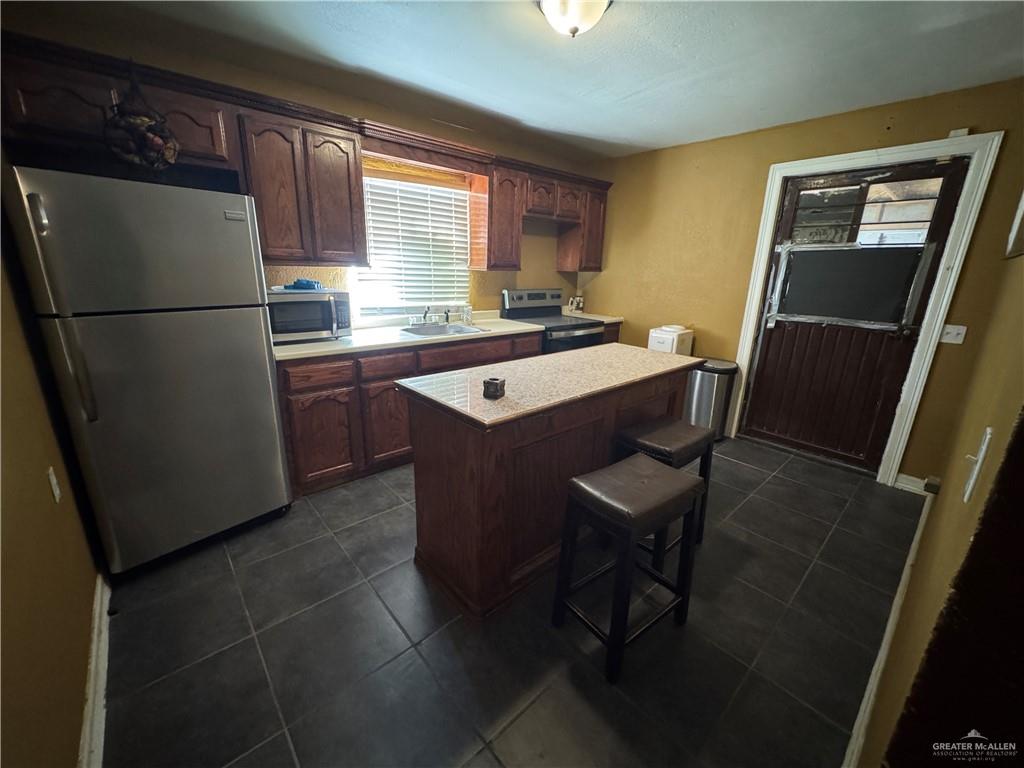 3757 Tom Gill Road Penitas, TX 78576 - Photo 3 of 12 a kitchen with a refrigerator a stove a sink dishwasher and a refrigerator