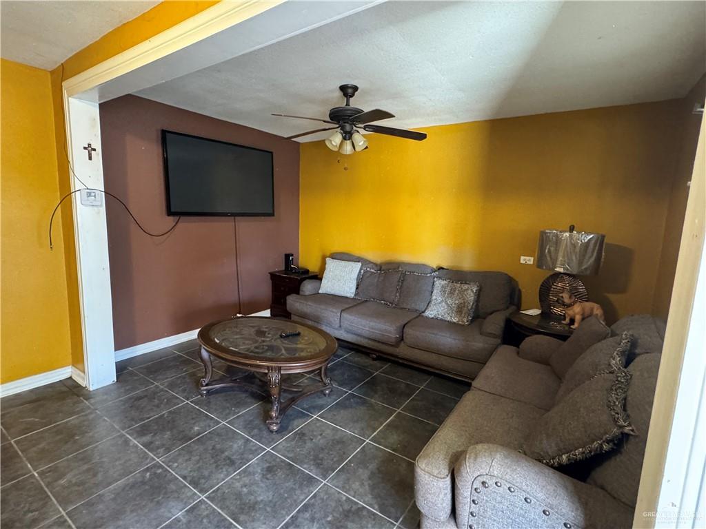 3757 Tom Gill Road Penitas, TX 78576 - Photo 6 of 12 a living room with a couch and a flat screen tv