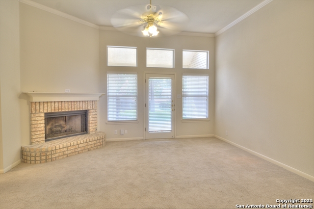 9902 Tezel Road San Antonio, TX 78254 - Photo 2 of 12 an empty room with chandelier fan and fireplace