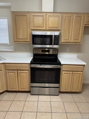 a kitchen with white cabinets and appliances