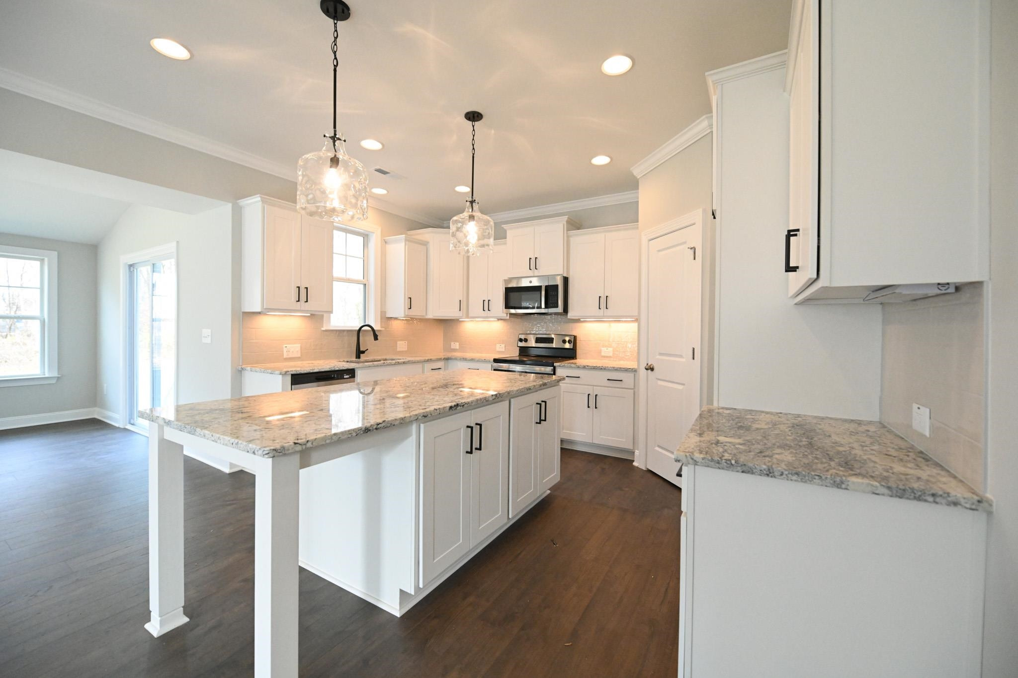 110 Freewill Place Raleigh, NC 27603 - Photo 13 of 39 a large kitchen with kitchen island a large counter space a sink appliances and cabinets