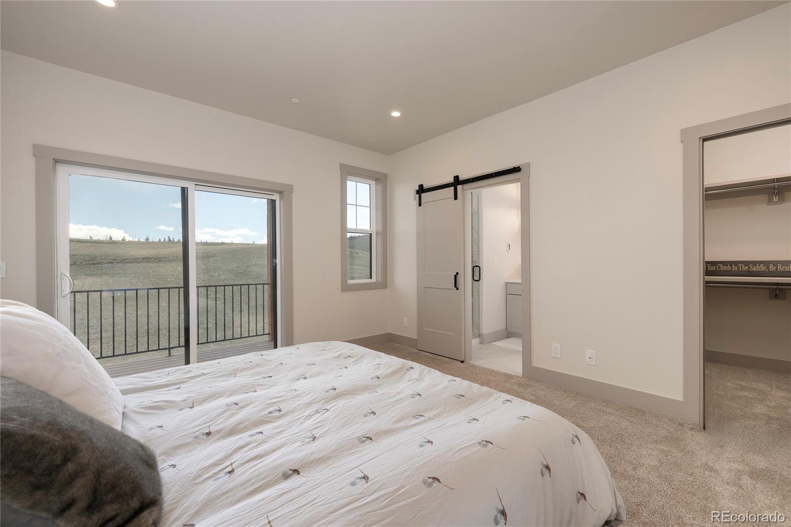 235 Eagle Ridge Circle Granby, CO 80446 - Photo 14 of 34 a bedroom with a large bed and a large window