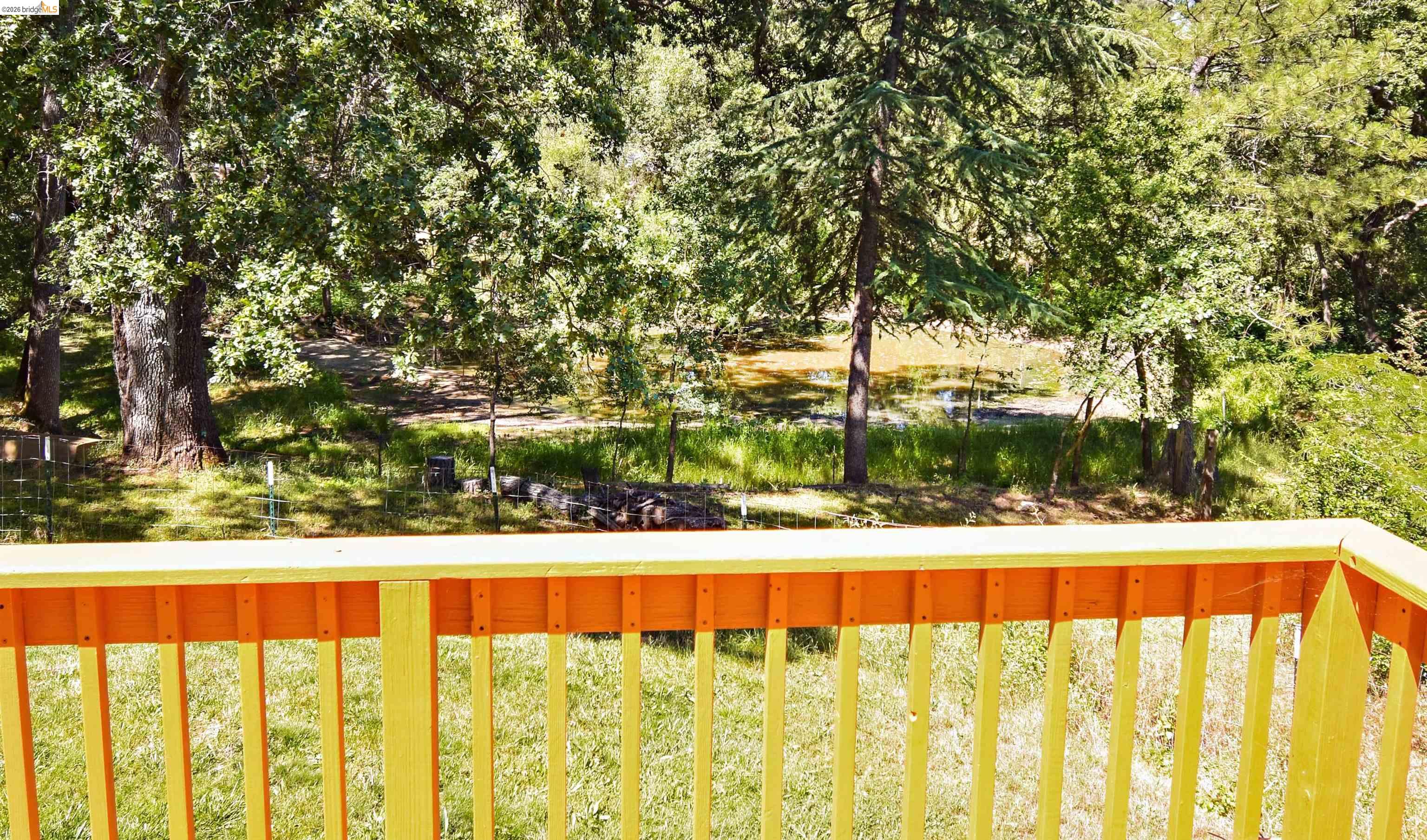 13904 Tuolumne Road Sonora, CA 95370 - Photo 31 of 44 Expansive outdoor space featuring a body of water framed by mature trees, lush greenery, and a natural landscape