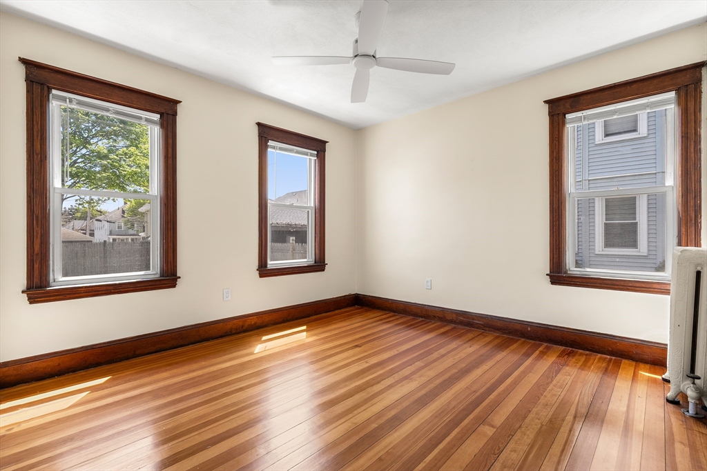 2 Thorndike Street, Unit 2 Arlington, MA 02474 - Photo 18 of 22 a view of an empty room with wooden floor and a window