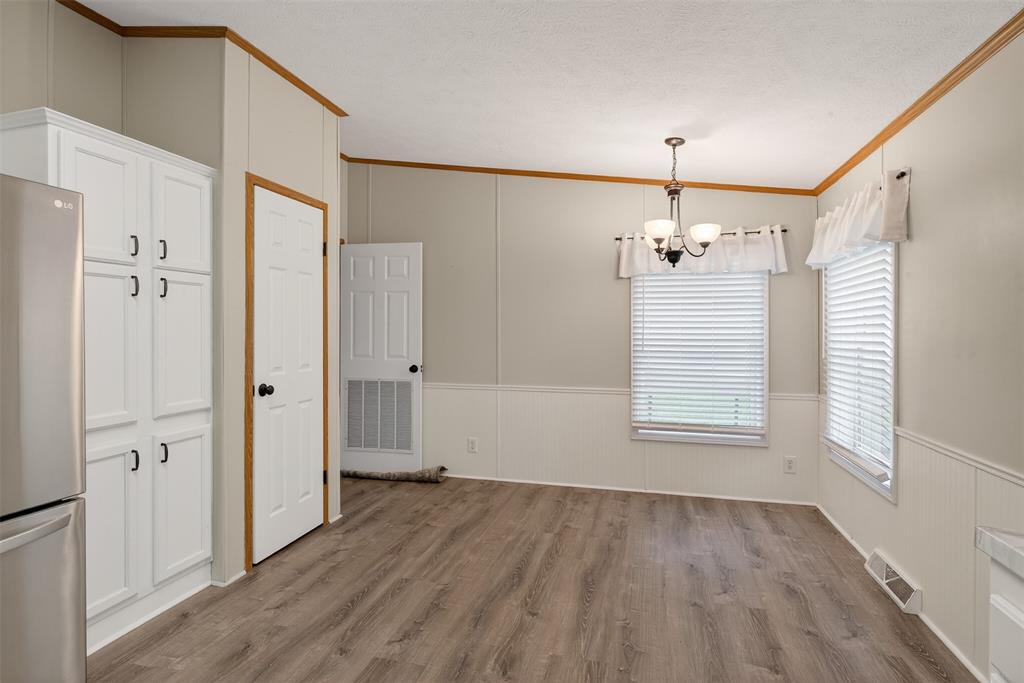 1202 Princeton Road Princeton, LA 71067 - Photo 13 of 32 an empty room with wooden floor chandelier and windows