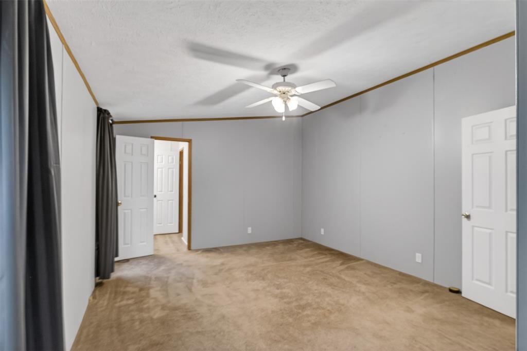 1202 Princeton Road Princeton, LA 71067 - Photo 19 of 32 an empty room with a chandelier fan and windows