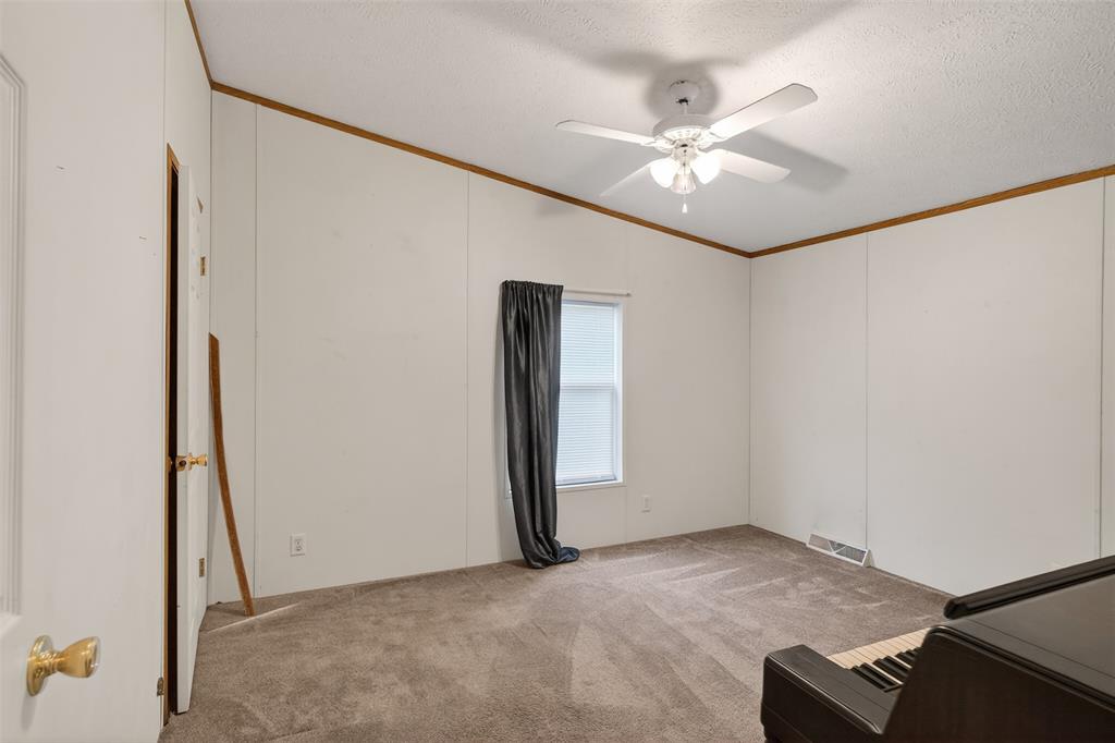 1202 Princeton Road Princeton, LA 71067 - Photo 26 of 32 an empty room with a ceiling fan and a window