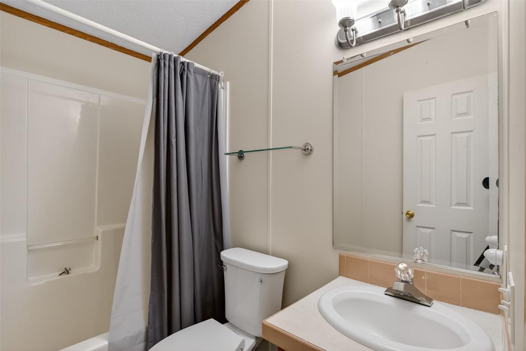 1202 Princeton Road Princeton, LA 71067 - Photo 28 of 32 a bathroom with a sink a toilet a mirror and shower