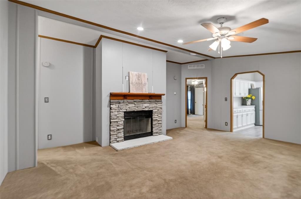1202 Princeton Road Princeton, LA 71067 - Photo 8 of 32 a view of an empty room with a fireplace and a ceiling fan