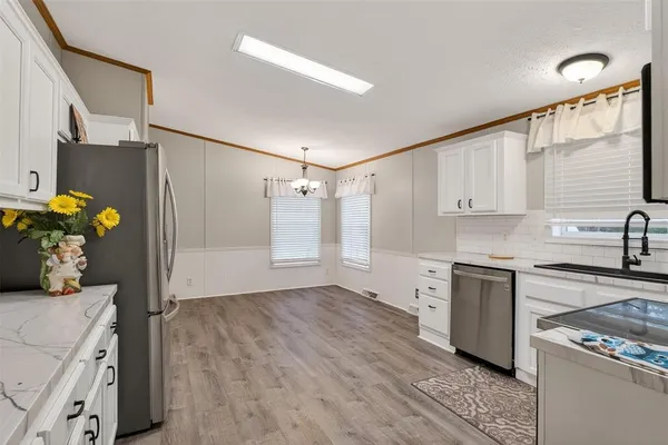 a kitchen with stainless steel appliances granite countertop a refrigerator and a stove top oven