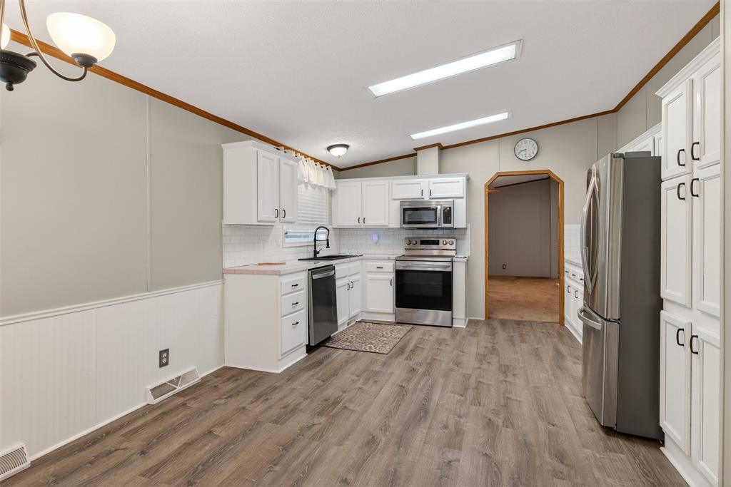 1202 Princeton Road Princeton, LA 71067 - Photo 10 of 32 a kitchen with stainless steel appliances a refrigerator sink and cabinets