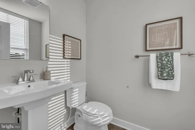 a bathroom with a toilet a sink and mirror
